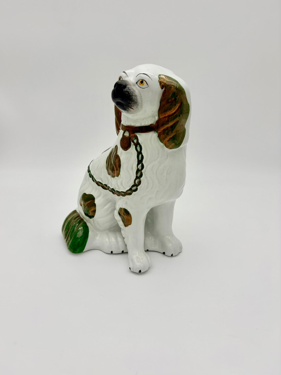 Ceramic dog figurine with a chain on a white background