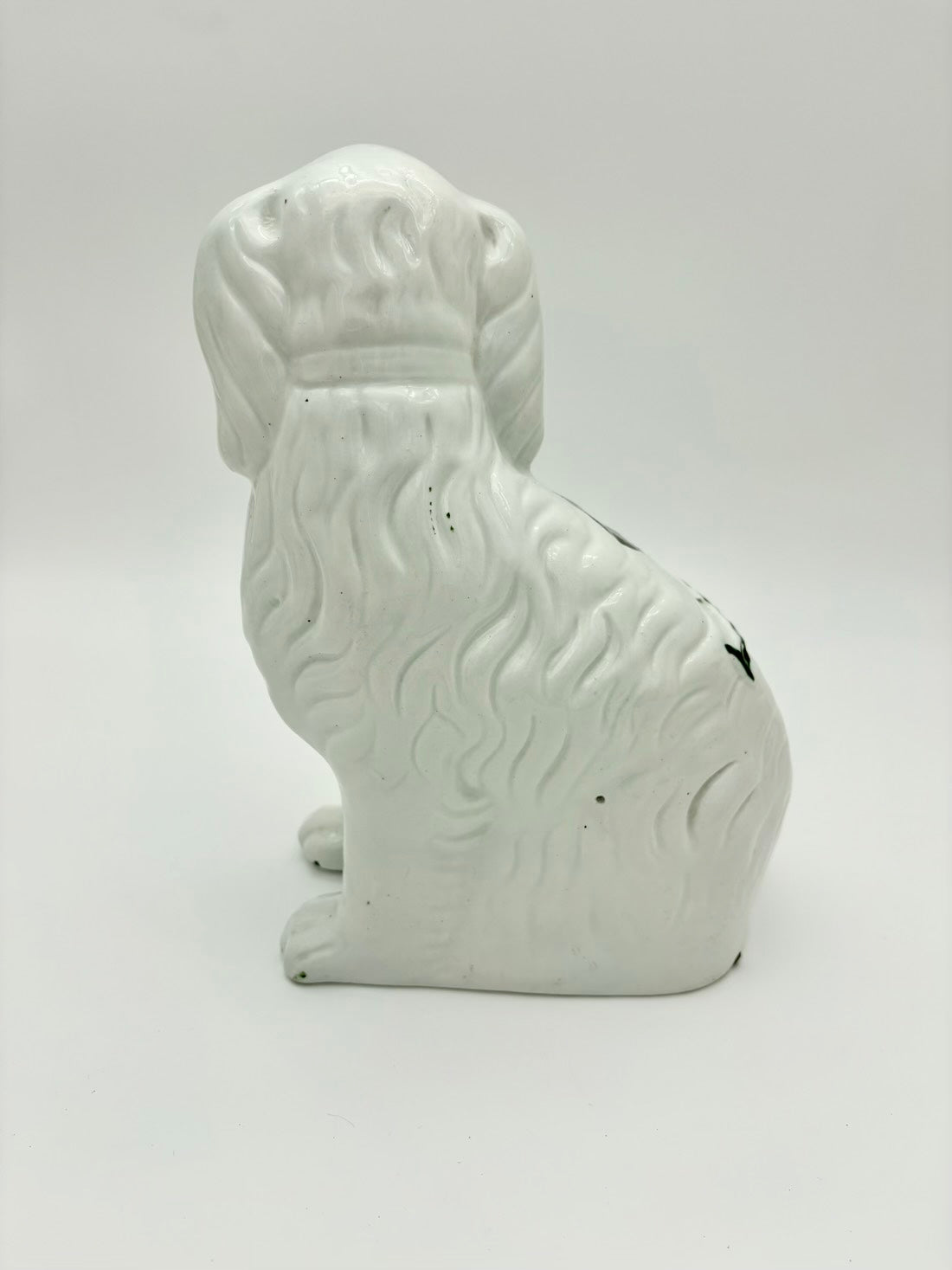 White ceramic dog-shaped object on a light gray background